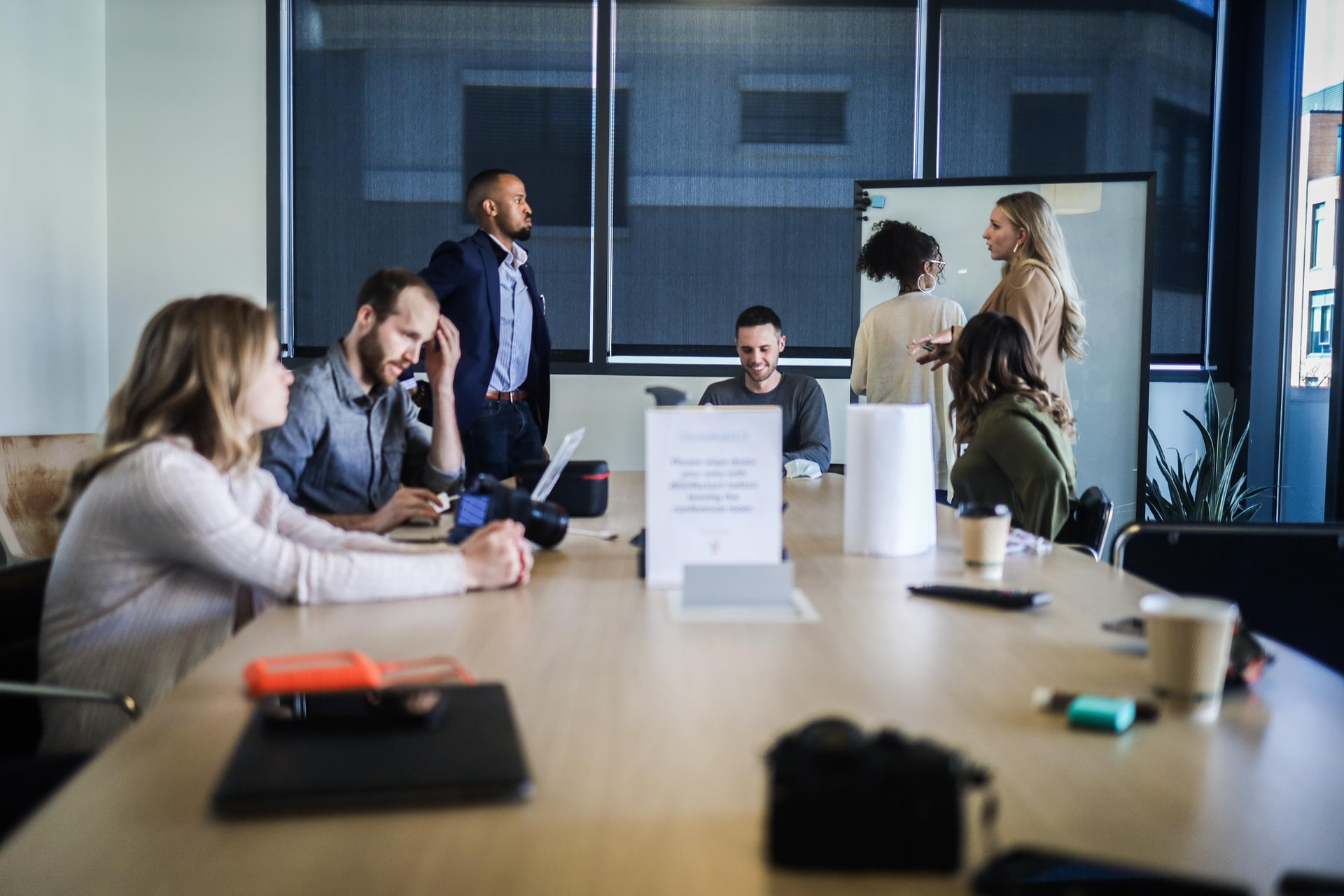 Les membres d'une équipe dans une pme travaillant ensemble sur un projet avec l'accompagnement stratégique d'un consultant en stratégie d'affaires pour améliorer la performance de leur entreprise