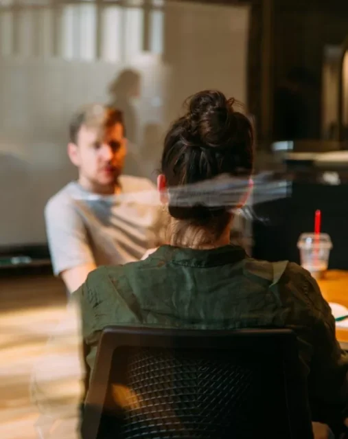 Discussion entre collègues du plan d'implantation avec le coach OKR dans l'entreprise.